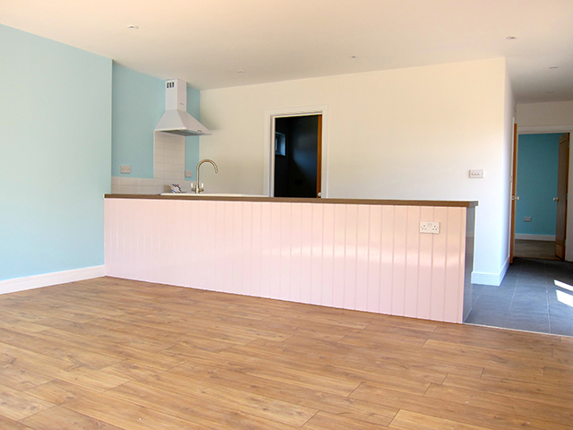 The kitchen area is discreetly situated in the main living space