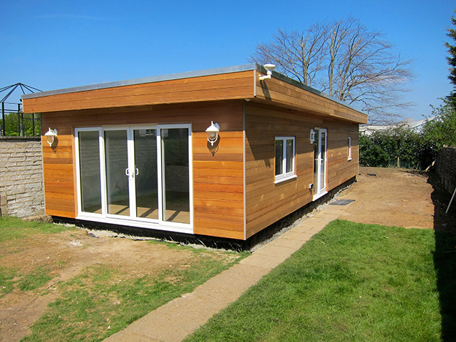 The annexe features cedar cladding on three sides and Building Regulation friendly Cedral weatherboard on the boundary side