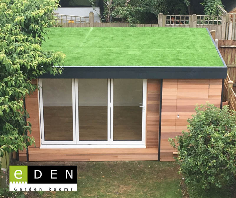 Garden room with doors on two sides and artificial grass roof