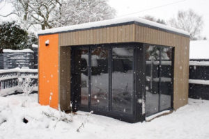 The orange rendered panel makes this garden room pop, even in the snow