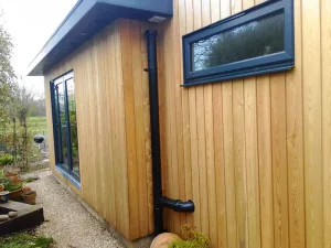 Slate grey doors and windows have been mixed with larch cladding