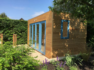 Larch clad garden office with blue doors