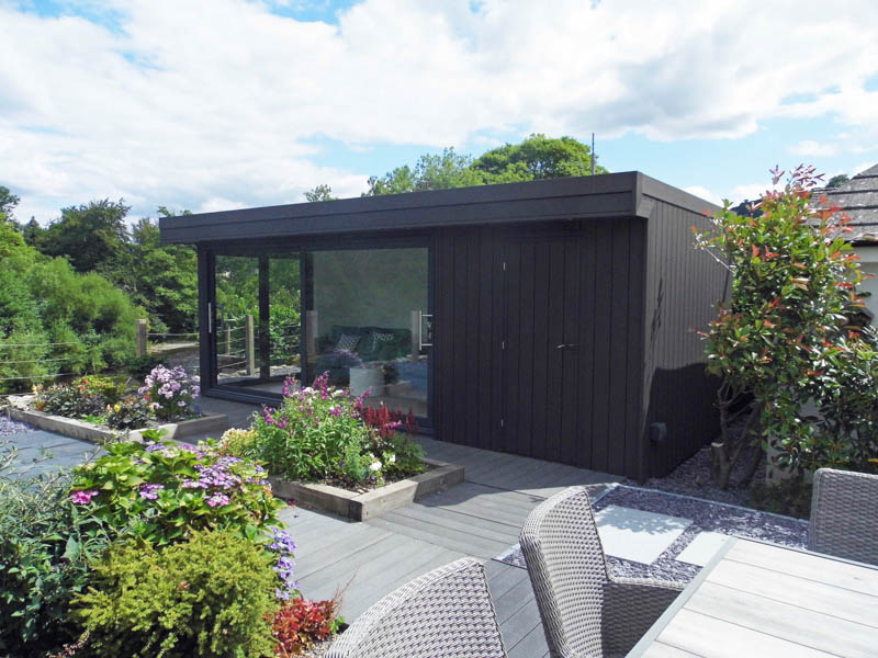 Outdoor sitting room with black cladding and views of a river