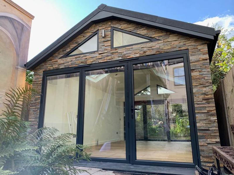 Garden room clad with Ochre Norstone cladding
