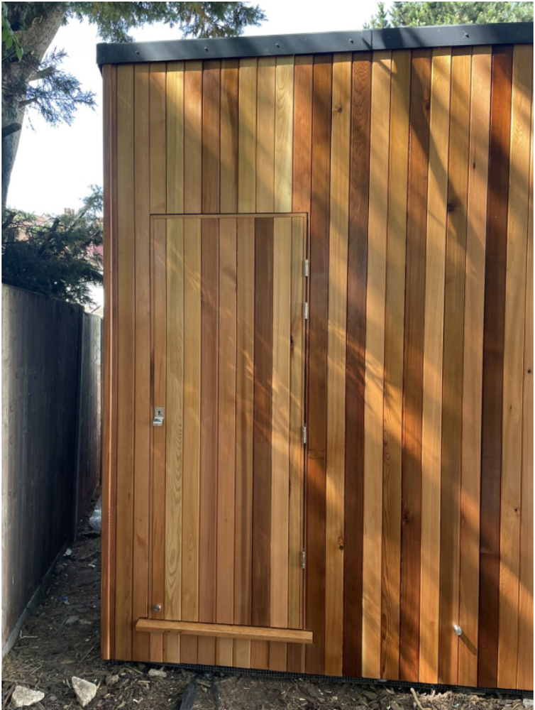 Cedar clad door blends into the wall cladding
