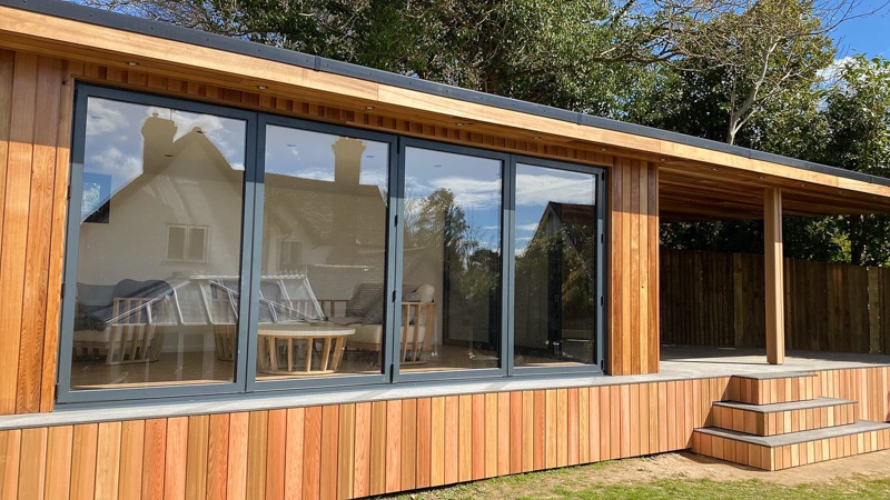 Ark Design build have mixed Cedar cladding with dark grey aluminium bi-fold doors