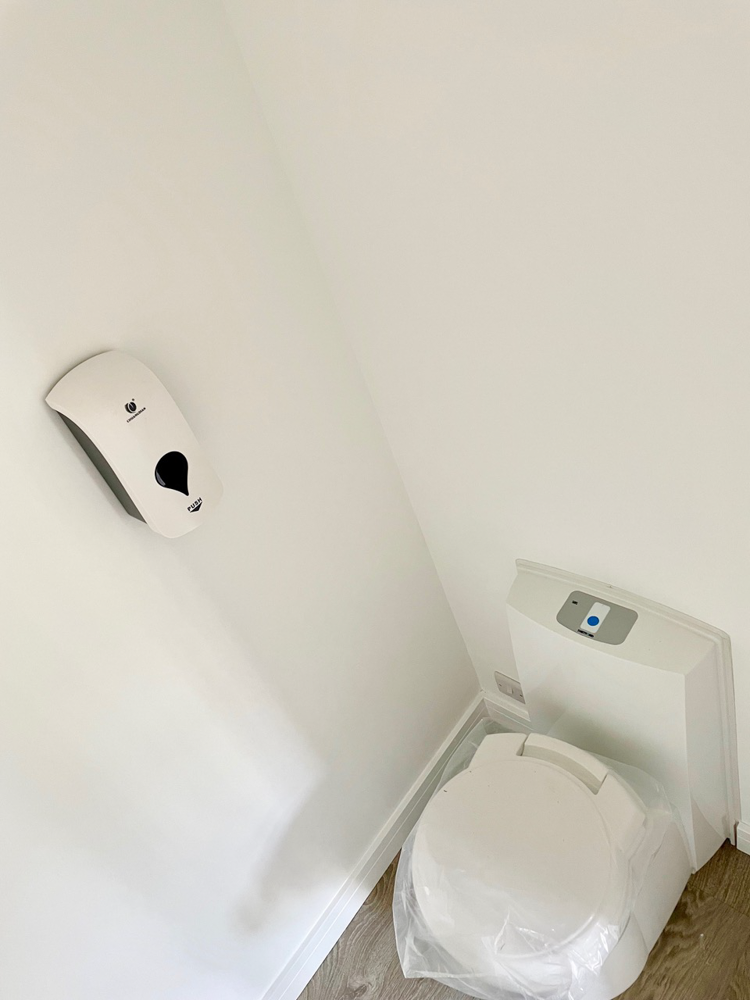 A modern cassette toilet has been installed in the office gym