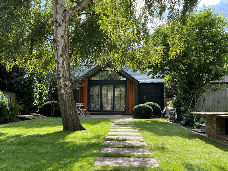 The garden room sits well in the established garden