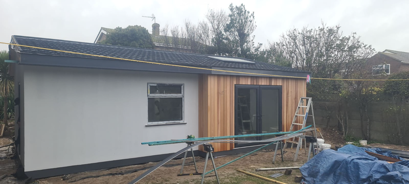 The annexe has been finished externally with low-maintenance finishes - Western Red Cedar and render