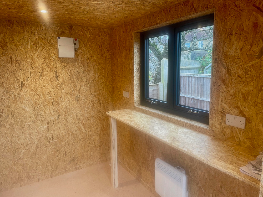 An OSB lined storage room sits alongside the fully insulated garden office