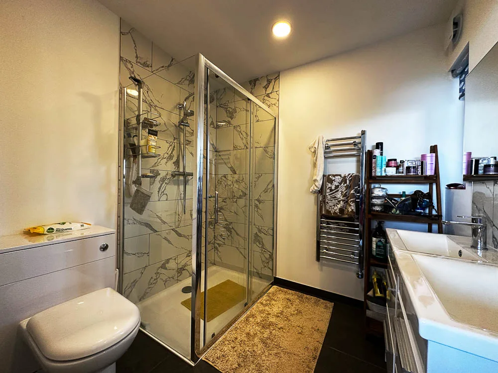 The ensuite shower room features his and hers vanity units