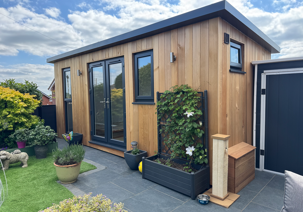 The wide but narrow garden room slots into the end of the garden but doesn't dominate the space