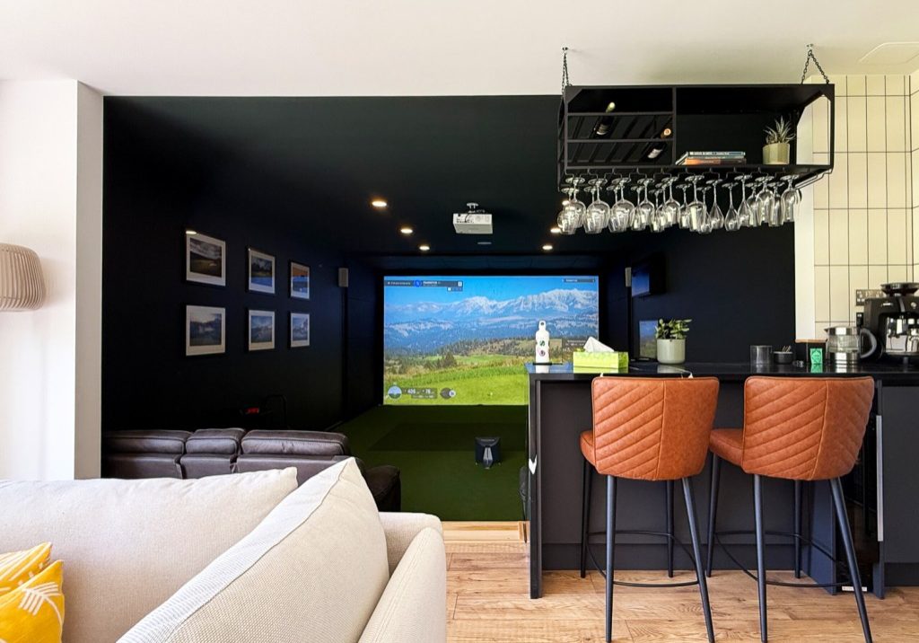 View from the lounge sofa over the bar and down into the lit simulator screen beyond