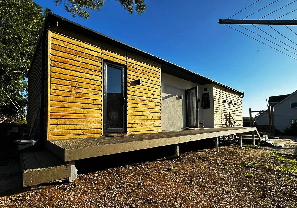 The A Room in the Garden design features Redwood weatherboard and white render finishes