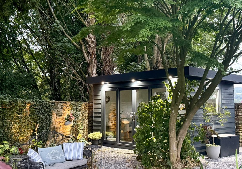 Anthracite Hardie Plank cladding and uPVC doors and windows sit well with the natural tones of the garden