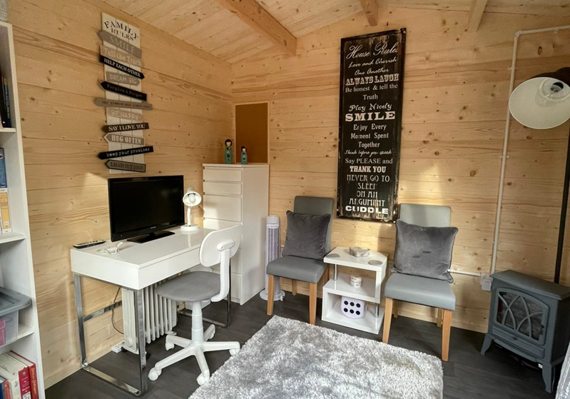 Inside an insulated log cabin office by Hargreaves Garden Spaces