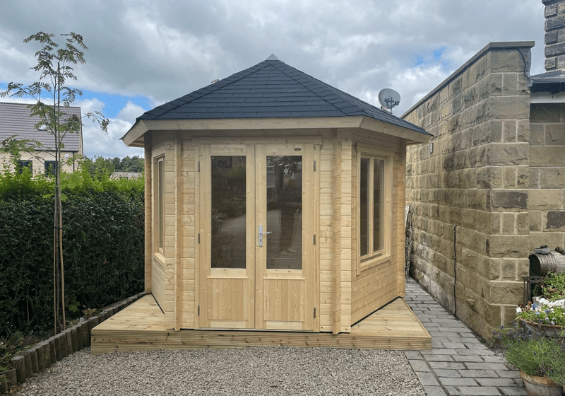 Hexagonal insulated log cabin by Hargreaves Garden Spaces