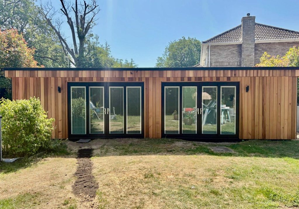 Vertically clad Western Red Cedar garden room by Executive Garden Rooms with two sets of anthracite sliding doors