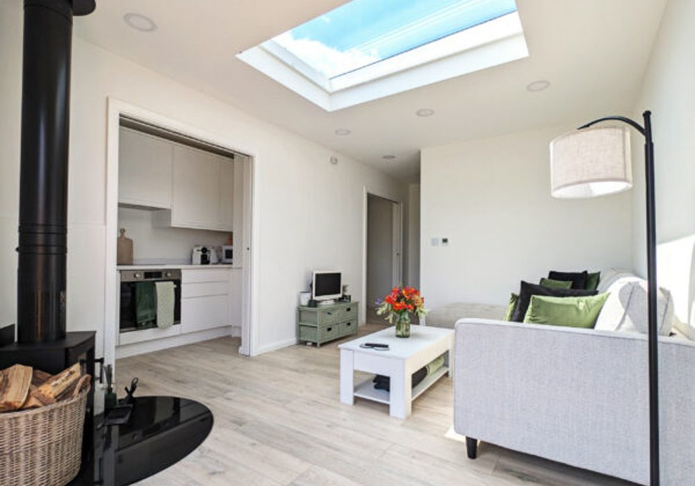 The living room is light and airy thanks to the bifold doors and large roof window