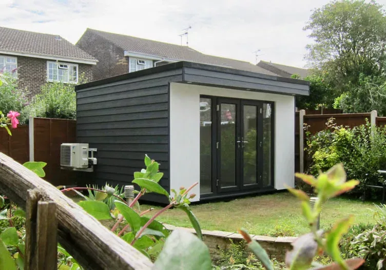 Garden office with grey Cedral and white render walls