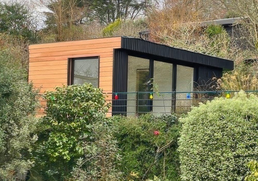 The garden office nestles into the mature garden planting