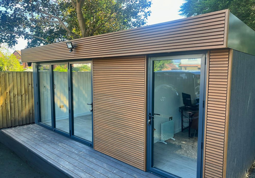 The finished building features slatted composite cladding on the front elevation